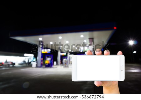 Man use mobile phone, blur image inside gas station at night as background.