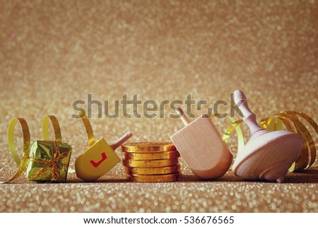 Image of jewish holiday Hanukkah with wooden dreidel (spinning top) on the glitter background