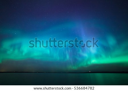 Beautiful northern lights aurora borealis over lake in finland Royalty-Free Stock Photo #536684782