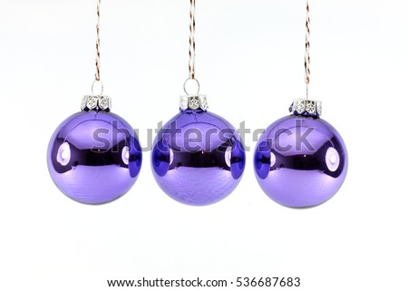 Three Purple Christmas balls photographed on a white background