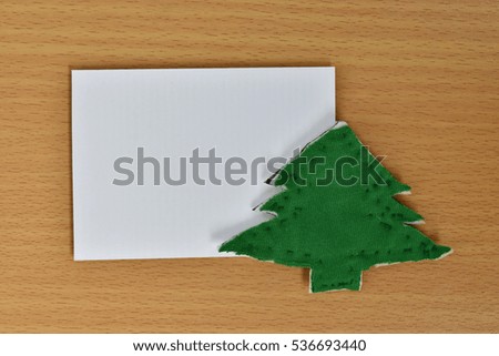 blank paper with green fabric christmas tree on wood background.  