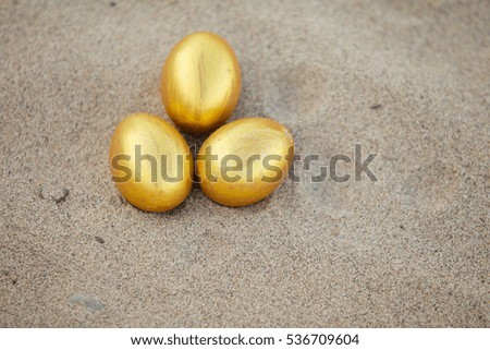 Golden egg isolated on Sand background