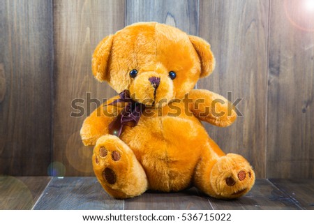 Teddy Bear toy alone on wooden floor.