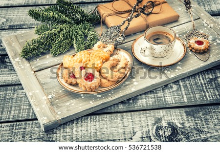 Christmas cookies with coffee and decorations on rustic wooden background. Vintage style toned picture