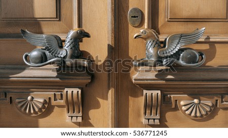          Door handles in the form of griffins, mythical creature with the body of a lion, an eagle's head and wings
