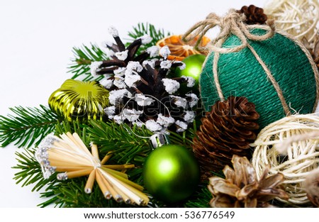 Christmas handmade ornaments and snowy decorated pine cones. Christmas background with fir branches, dried orange slices and rustic balls.  