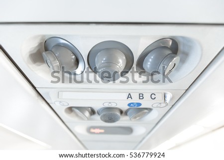 Overhead console in the modern passenger aircraft. air conditioner button and lighting switch