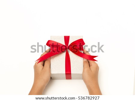 Holding gift box with red ribbon on  isolated on white background.