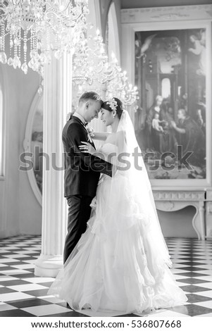 Side view of romantic wedding couple standing in church