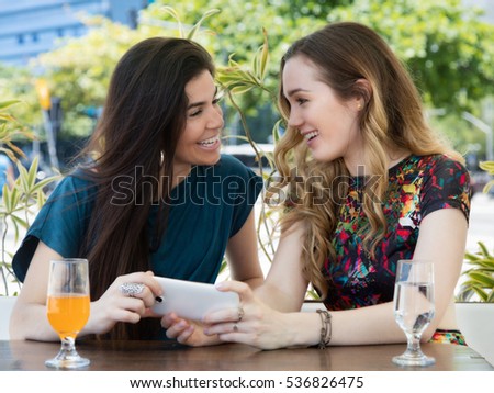 Two woman with phone at restaurant