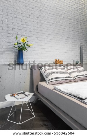 Bedroom with matrimonial bed and white brick wall