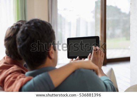 Father and Son Using Digital Tablet at Home