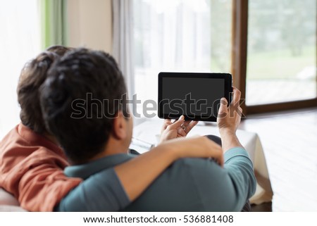 Father and Son Using Digital Tablet at Home