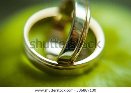 A blurred picture of wedding rings lying on the green apple