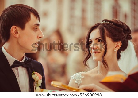 beautiful and young bride and groom standing at wedding ceremony