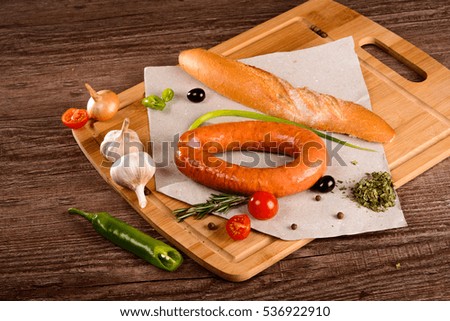 sausage with spices on a chalkboard next to the fresh vegetables and bread
