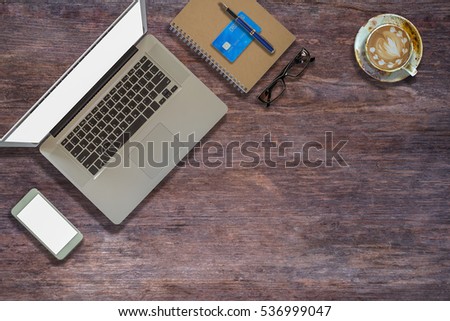 Laptop on Vintage Wooden desktop in modern office with accessories - top view on desk from above.