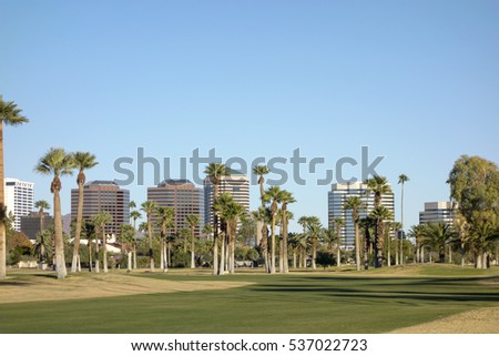 View at Phoenix Downtown from Encanto Park green lawns, Arizona; Copy space in clear blue sky