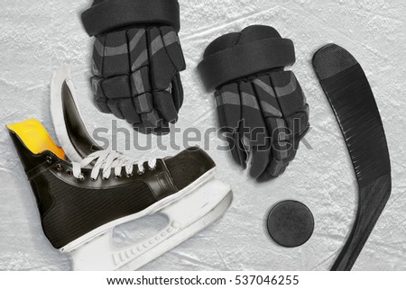 Hockey stick, gloves and puck on the ice arena. Concept