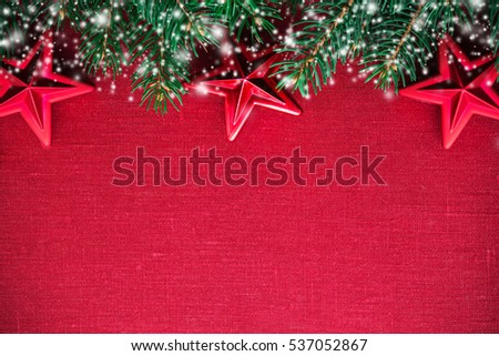 Christmas background with xmas tree, red stars and blurred snow on red canvas background. Merry christmas greeting card, banner, frame. Winter holiday theme. Happy New Year. Space for text.