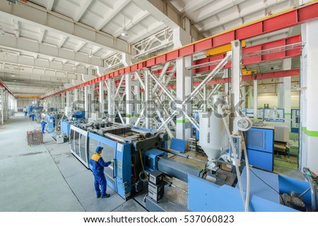 Industrial injection molding press machine for the manufacture of plastic parts using polymers in the management of worker Royalty-Free Stock Photo #537060823