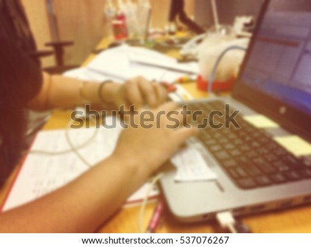Blurred photo of woman is typing on laptop keyboard, color filter effected 