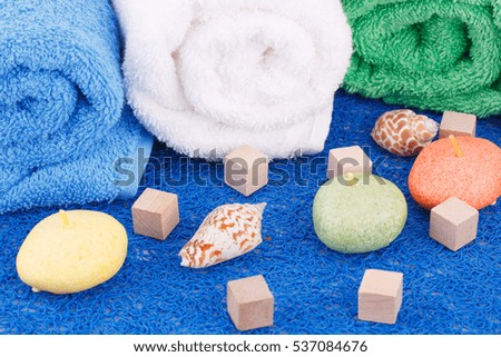 Colorful rolled towels with candles and shells closeup picture.
