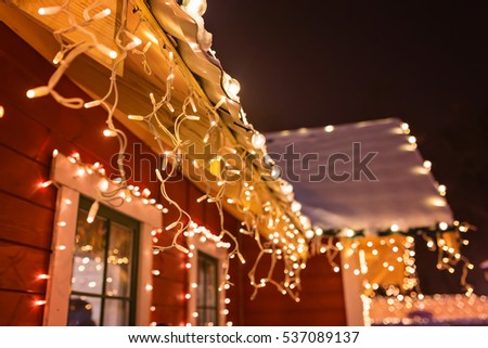 unusual christmas wreath on window. luxury decorated store front with garland lights in european city street at winter seasonal holidays Royalty-Free Stock Photo #537089137