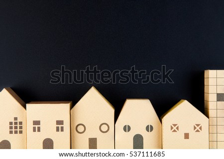 Home architectural model paper box cubes on black background with copy space.Real estate concept.