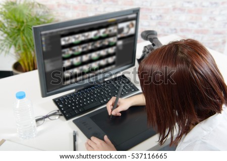 young female designer using graphics tablet for video editing