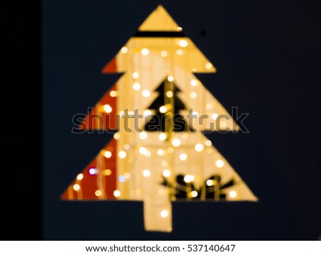Blurred silhouette of christmas tree lit from behind