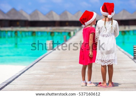 Little girls in Santa hats during Christmas vacation in hot country