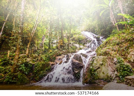 The waterfall view in the forest where is made to be home stay in Thailand with the flare from the sky.