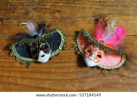 Two miniature masks on a wooden table