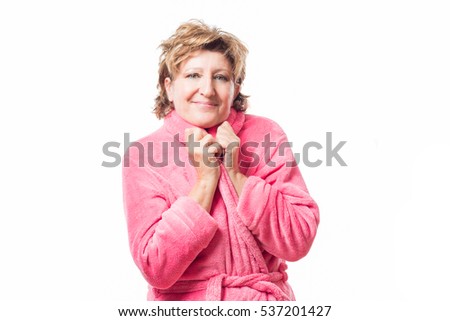 
Adult woman dressed in a bathrobe sitting at home making a gesture of being cold or being warm at home isolated on white background