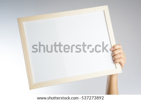 Hand holding blank wooden frame on white background