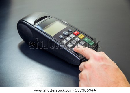 Payment card in a bank terminal. The concept of of electronic payment. hand pin code on pin pad of card machine or pos terminal good photo