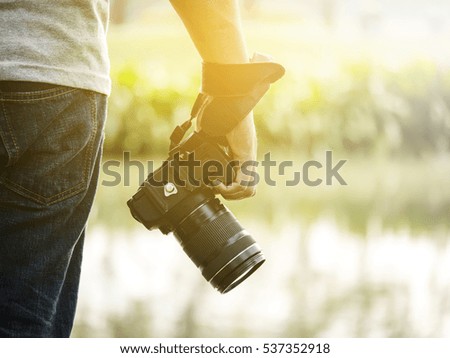Photographer standing and holding camera in the park