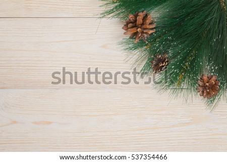 winter background with pine needles and cones on white rustic table