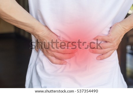Man's hands on his back with red spot as suffering on backache. Male person sick from lower back pain from Herniated or slipped discs,Degenerative, sacroiliac joint, spinal stenosis, Pancreatic Cancer Royalty-Free Stock Photo #537354490