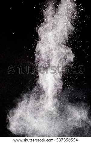Freeze motion of white particles on black background. Powder explosion.