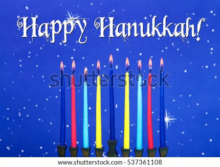 a nine-branched menorah (also called a Chanukiah or Hanukiah) burning candles to celebrate Hanukkah against a blue starry background.