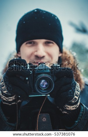 Young man with vintage camera outdoor. concept of winter photography