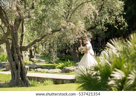 Beautiful Bride Portrait outdoors wedding day. Fashion bride gorgeous beauty walking in park at marriage day, smiling happy bride portrait, series. Soft grane filter and sunny lights color