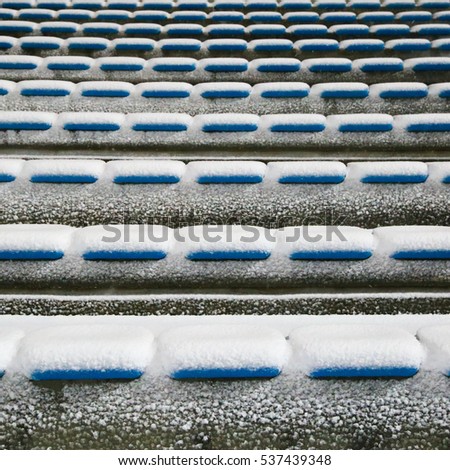 Row of stadium seats covered with snow in the winter