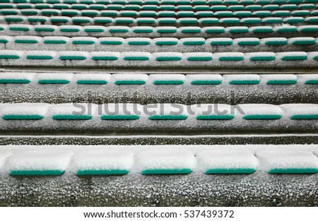 Row of stadium seats covered with snow in the winter