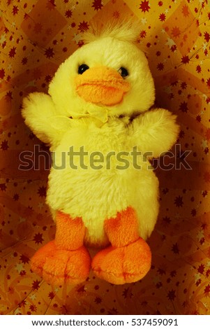 yellow toy Easter chick on a yellow background