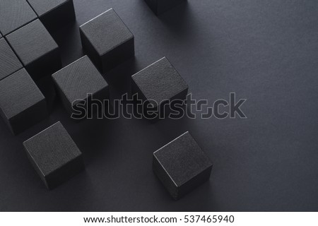 Black wooden cubes on a black background, top view. Abstract background with cubes with copy space. Royalty-Free Stock Photo #537465940