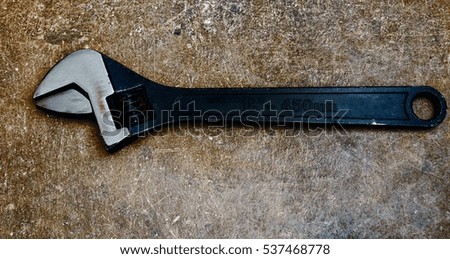 wrench on dark rusty background