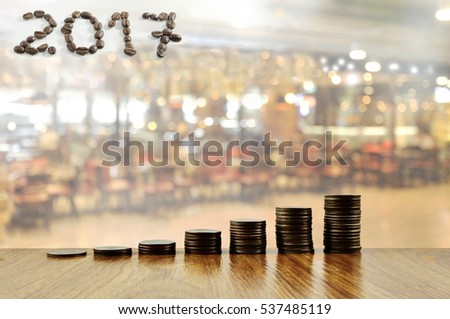 begin for mortgage concept by money house from coins on coffee shop or restaurant background.Growth coin and hand carry on wood house. coffee beans on isolate background 